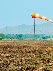 Windsock indicator of wind in meadow with beautiful scenic. Flying windsock or wind vane in field. meteorology. Airport windsock. Air field direction sign , Air sock, Drogue, Wind sleeve, Wind cone.