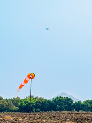 Windsock indicator of wind in meadow with beautiful scenic. Flying windsock or wind vane in field. meteorology. Airport windsock. Air field direction sign , Air sock, Drogue, Wind sleeve, Wind cone.
