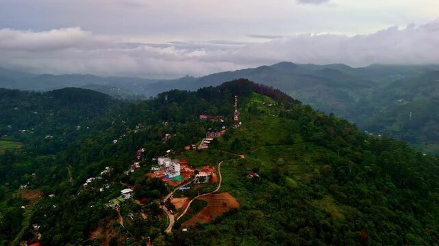 Experience the breathtaking beauty of Ella, a charming town in the Uva Province of Sri Lanka. Lush greenery spreads across the landscape, with rolling hills and serene surroundings visible from above.