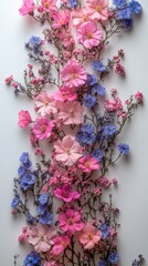 A vibrant arrangement of pink and blue flowers cascading down a white background, showcasing nature's beauty