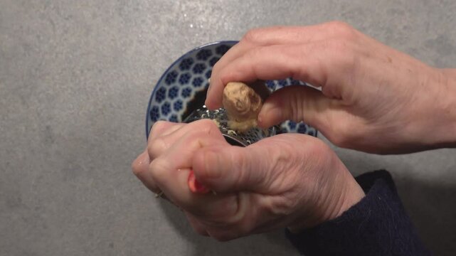 A cook mixes a dipping sauce with soy, garlic, ginger, fish sauce, and chili. 