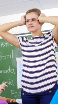 School kids throwing paper balls on teacher in classroom