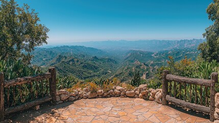 Scenic mountain viewpoint showcasing lush valleys and distant peaks under a clear blue sky