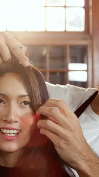 Male hairdresser styling a womans hair