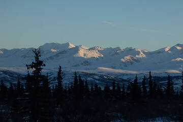 Sun on mountaintops on winter afternoon in interior Alaska