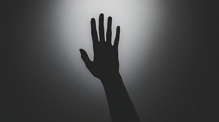Black and White Silhouette of a Hand Reaching Out Against a Soft Gray Background