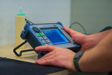 Industrial NDT Inspector Setting Up Ultrasonic Testing Equipment for Quality Control. Technician Configuring Portable UT Device for Non-destructive Material Inspection