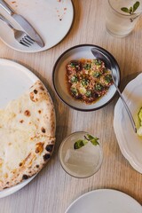 Mesa gourmet con pizza, albóndigas y cócteles refrescantes
