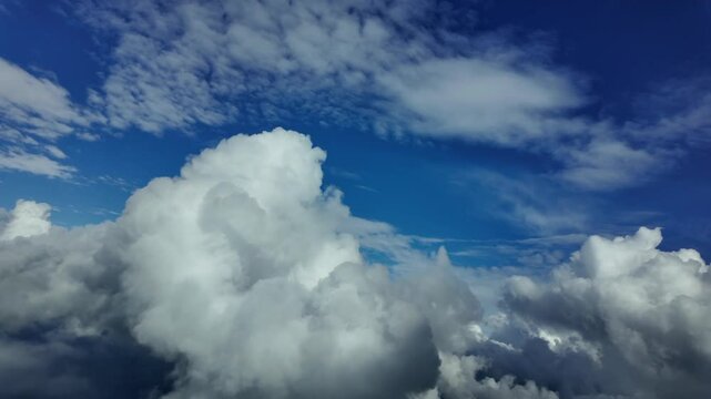 A real time flight through cottony stormy cumulus clouds. Aerial footage taken from a jet cokpit while flying over the Mediterranean Sea near Menorca Island at 2000m high. Daylight. 4K 60FPS
