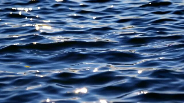Calm ocean waves with sunlight reflections, serene and tranquil water scene. Nature and relaxation concept