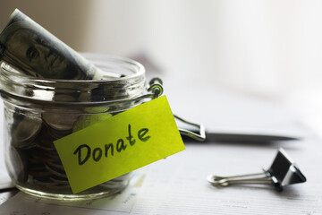 Donation Jar with Money and 'Donate' Label for Charity Fundraising and Giving