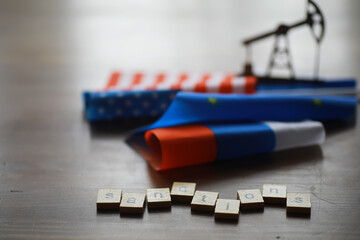 Sanctions Concept with Flag Ribbons and Oil Rig in Background