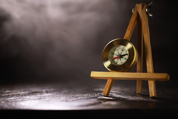 Vintage Compass on Wooden Easel with Smoky Background - Navigation, Direction, Adventure