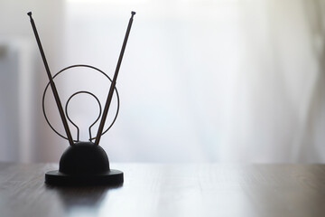 Minimalist Wire Sculpture on Wooden Surface with Soft Natural Light Background