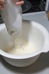 In a mixing bowl, pour flour from the bag