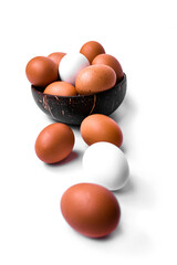 Wooden bowl filled with brown and white chicken eggs, on a white background.