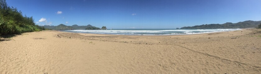 Fototapeta premium Golden Sands and Blue Waves: The Beauty of Pacitan Beach