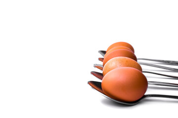 brown eggs arranged in spoons on a white background