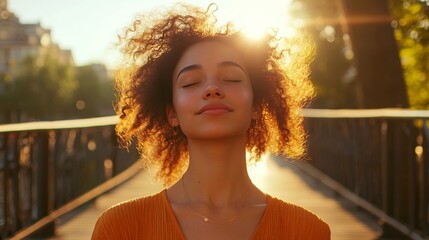 Naklejka premium young pretty woman stands on a bridge with her eyes closed and a smile on her face, enjoying the sun's rays, concept: take care of yourself, 16:9