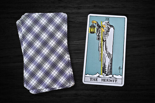 La carte de l'Ermite du jeu Rider-Waite, pos&eacute;e sur un fond en bois sombre. Elle symbolise l&rsquo;introspection, la sagesse et la qu&ecirc;te de v&eacute;rit&eacute;, avec un vieil homme portant une lanterne et un b&acirc;ton.