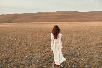 Woman standing in white dress in open field with mountains in background, travel beauty serenity nature landscapetripdestination