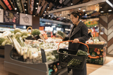 Woman Choosing Fresh Produce in Modern Grocery Store