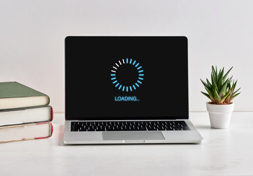 Laptop Showing Loading Screen with Books and Plant - Powered by Adobe