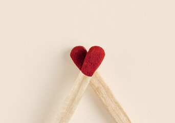 Two matches forming a heart shape are creating love and affection.