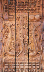 Traditional moroccan wood carving shutter with animals like crocodiles, turtle, antelope. Street shop of traveller souvenirs in medina of Marrakech, Morocco. Tourist wooden souvenir on market street