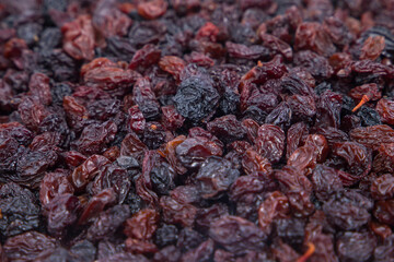 Raisins as background, closeup of raisins. Selective focus.