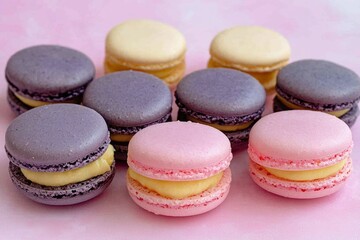 Fototapeta premium Vibrant macarons in shades of purple, pink, and yellow are beautifully arranged on a soft pastel background, showcasing their delicate fillings. Perfect for dessert lovers