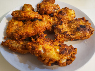 A close-up photo of a plate of fried chicken wings.
