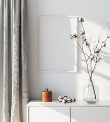 Fototapeta premium Minimalist white interior with a framed picture. cotton branches in a vase. and a wooden box on a white dresser
