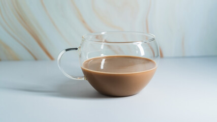 Warm cup of chocolate drink on a minimalist table with a soft background