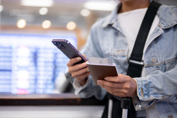 A close-up of a woman checks her flight boarding time on her smartphone.