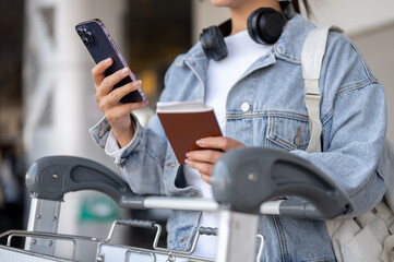 A close-up of a female traveler is waiting for her taxi at an airport pickup point.