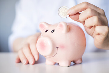 pink piggy bank for saving money on a light background.