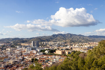 Obraz premium Photo of the streets of the city of Malaga in Spain showing an aerial view of the city centre with the high rise apartments and mountains in the background on a sunny day with white clouds in the sky