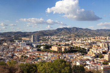 Aerial view of the streets of the city of Malaga in Spain showing a view of the city centre with the high rise apartments and mountains in the background on a sunny day