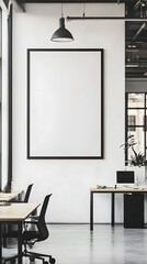 A minimalist, open-space office with shared desks and a large, framed blank canvas.