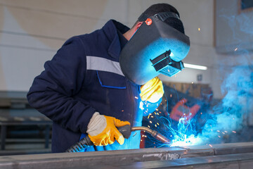 High-precision metal machining and welding process in an industrial workshop, including lathe...