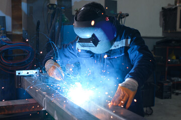 High-precision metal machining and welding process in an industrial workshop, including lathe...