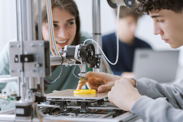 Students learning how to use a 3D printer in the lab