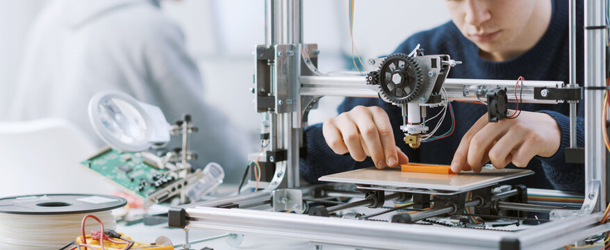 Student working with a 3D printer in the lab