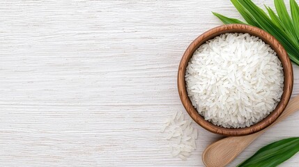Cooked rice in bowl, wooden spoon, leaves.  Food photography, website banner