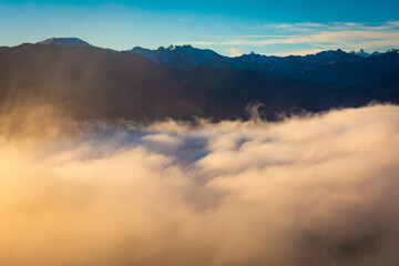 Berge über einem Nebelmeer im Sonnenaufgang in den Alpen von Tirol