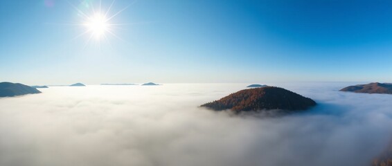 Obraz premium Aerial Panorama of Mountain Peaks Emerging from Thick Fog Under a Clear Blue Sky
