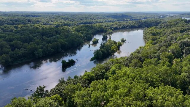 A cinematic drone swirls towards the Potomac River, revealing the stunning multiple paths of the water as they swerve elegantly, creating a breathtaking view of the river's winding path.