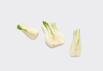 One half and two parts of fennel bulb are located on a gray background. Creative photo. Healthy...