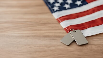 Obraz premium Elegant Military dog tags resting on a folded American flag placed on a wooden table under dim lighting creating a solemn and respectful atmosphere 
